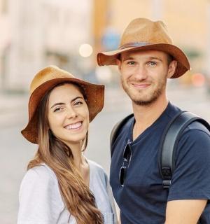 a man and a woman wearing hats on a street