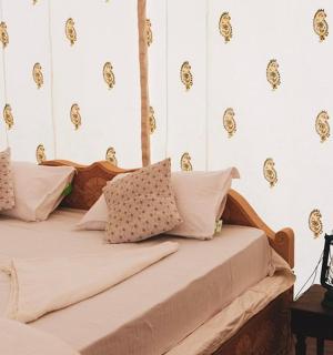 ložnice s postelí s bílo-zlatou tapetou