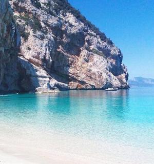 pláž s útesem a lodí ve vodě