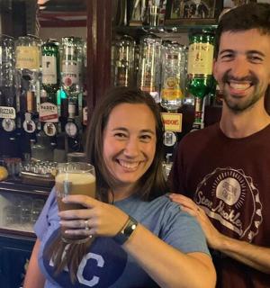 一名男子和一名女子手捧一杯啤酒