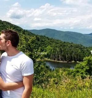 a man and a woman standing on top of a mountain