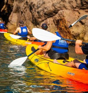 eine Gruppe von Menschen in Kajaks auf dem Wasser