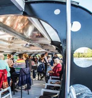 a group of people sitting on a boat on the water