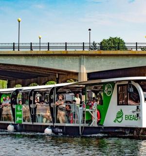 a bus on the water under a bridge