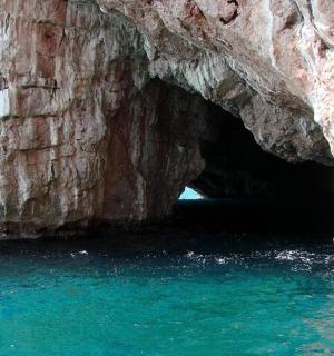 a cave in the side of a cliff with water
