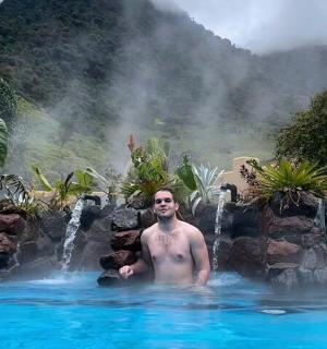 一名男子在有瀑布的游泳池里