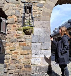 一名女子站在石墙旁