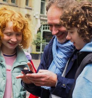 a group of people looking at a cell phone