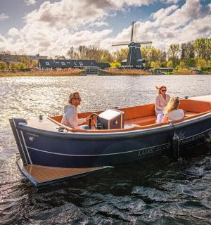 两名女子在水上的船上，船上有风车