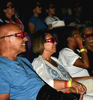 קבוצת אנשים יושבת בקהל ועונדת משקפי שמש