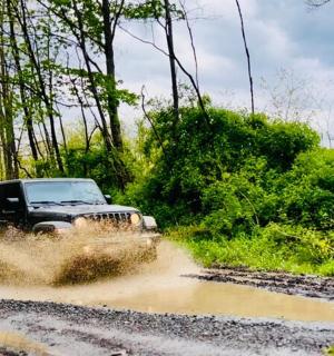en jeep kører gennem en mudret vej