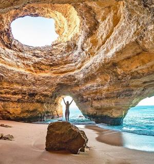 一名男子站在海滩上的洞穴里