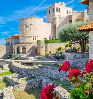 a view of a castle with flowers in the foreground
