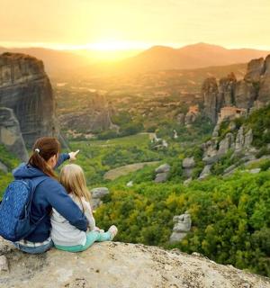 a woman and child sitting on top of a mountain