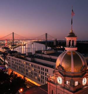 a building with a clock tower with a bridge in the background