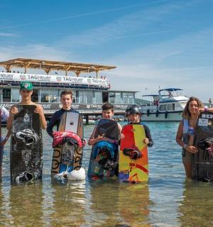一群人拿着滑雪板站在水中