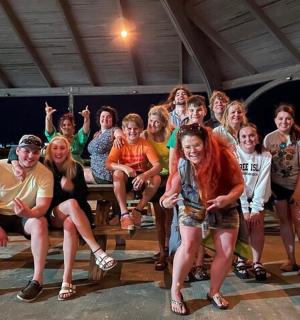 a group of people posing for a picture at a picnic table