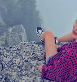 a woman sitting on top of a rock
