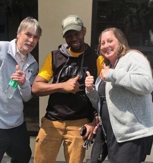 dva muži a žena ukazují palec nahoru