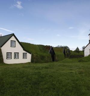 一座白房子旁边有一片草地的教堂