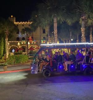 eine Gruppe von Menschen, die nachts mit einem Golfwagen fahren