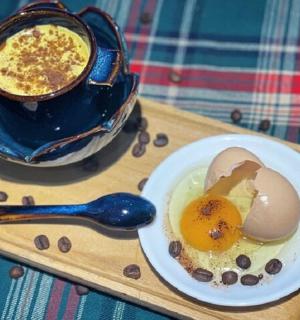 托盘上放着一盘鸡蛋和一杯咖啡
