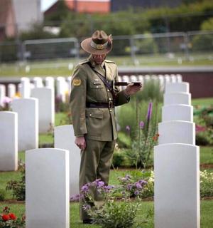 a man in a military uniform standing in a cemetery