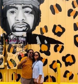 两个人站在一幅男人壁画前