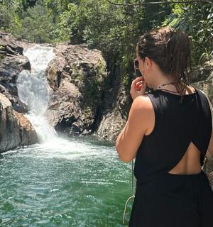 一名女子在瀑布前打电话