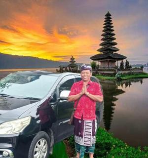 一名男子站在宝塔前的一辆汽车旁