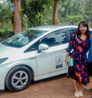 a man and a woman standing next to a small car