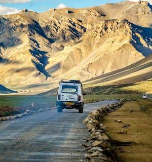 a truck driving down a road in the mountains