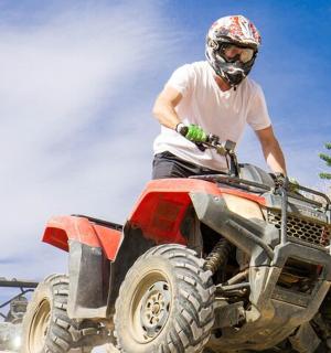 a man riding a quad bike on the beach