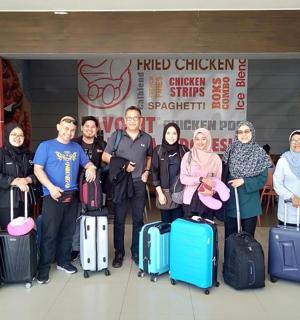 a group of people posing for a picture with their luggage