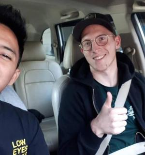 two men sitting in a car giving a thumbs up