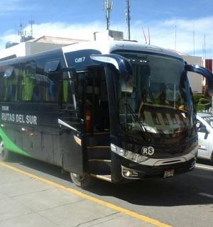 一辆黑绿色的巴士停在停车场