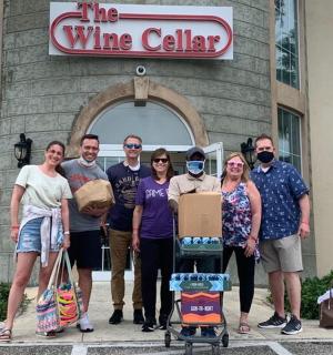 skupina lidí stojících před vinným sklepem