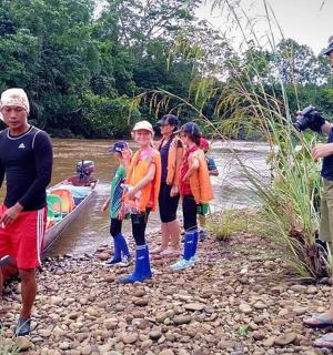 一群人在河边,一名男子拿着相机
