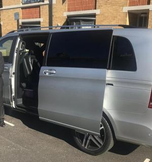 一名西装革履的男子站在一辆货车旁边