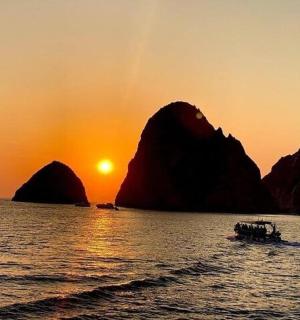 日落时分，水中的一艘船与群山