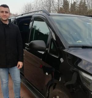 一名男子站在一辆黑色货车旁边