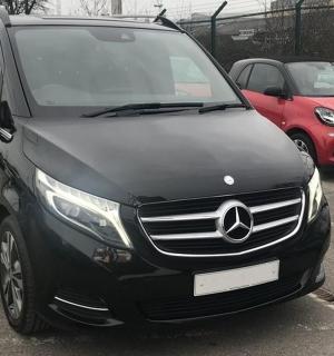 一辆黑色奔驰面包车停在停车场