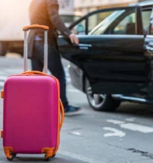 a person pulling a pink suitcase on the street