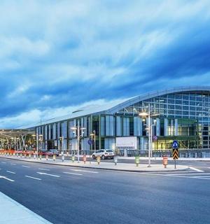 a large glass building with a road in front of it
