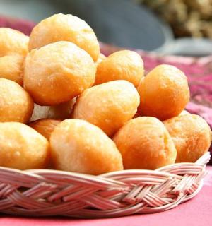 a pile of donuts in a basket on a table