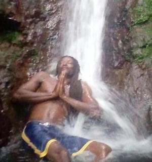 一名男子坐在瀑布前