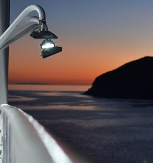 a light on the side of a boat with the ocean