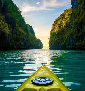 峡谷河流中央的一艘黄色皮划艇