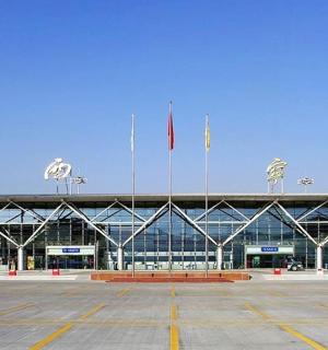 velká budova se dvěma vlajkami na parkovišti