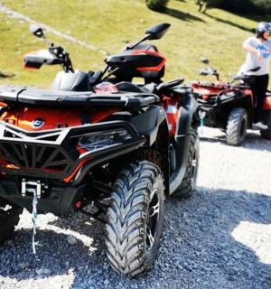 two atvs parked on the side of a dirt road